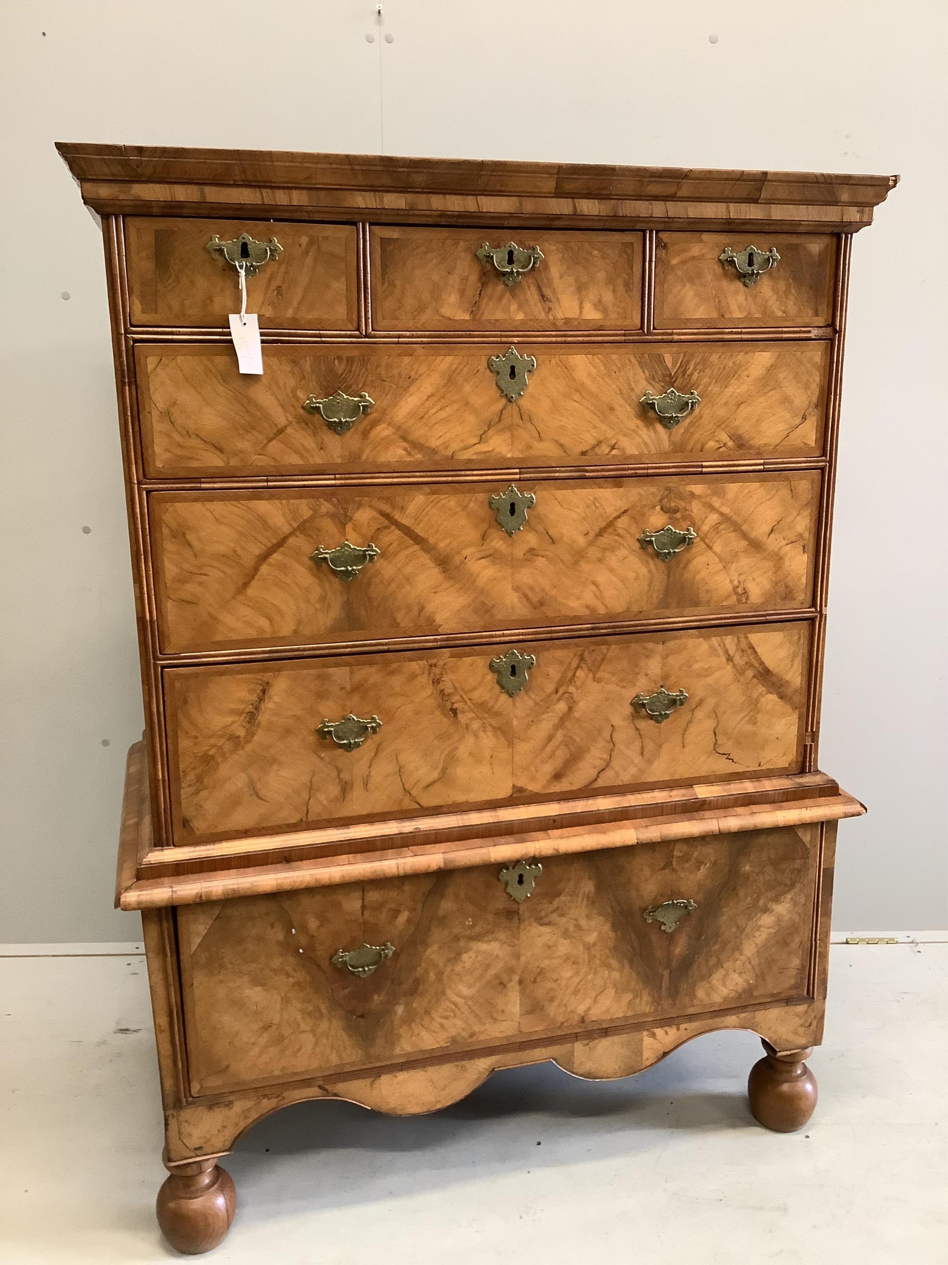 An early 18th century walnut chest on stand with later bun feet, width 106cm, height 147cm. Condition - fair